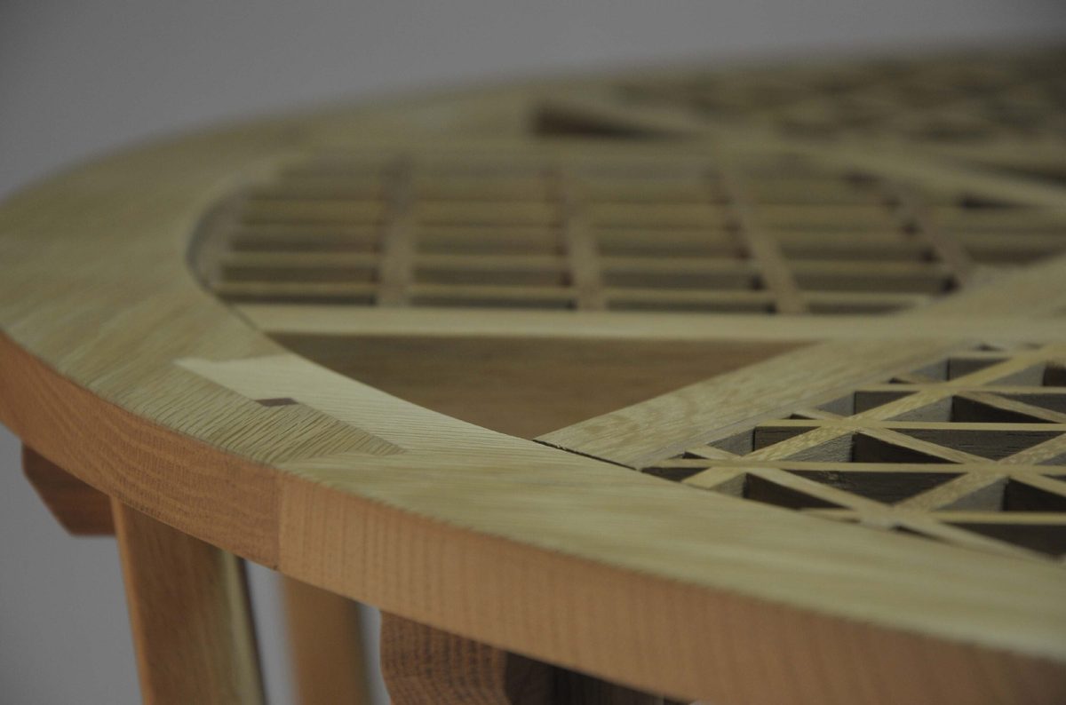 Close-up of a round table with a curved geometric lattice top.