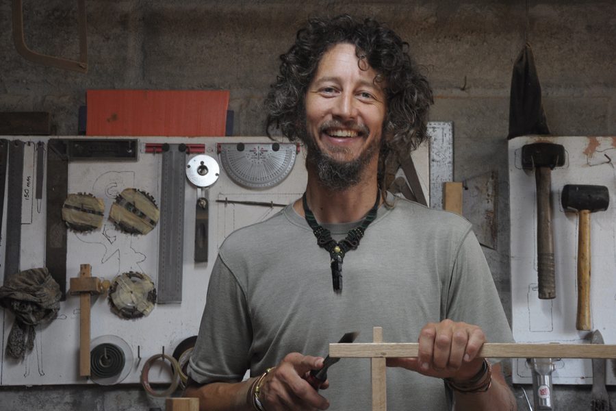 Wessel Gresse smiling in his workshop, surrounded by hand tools.